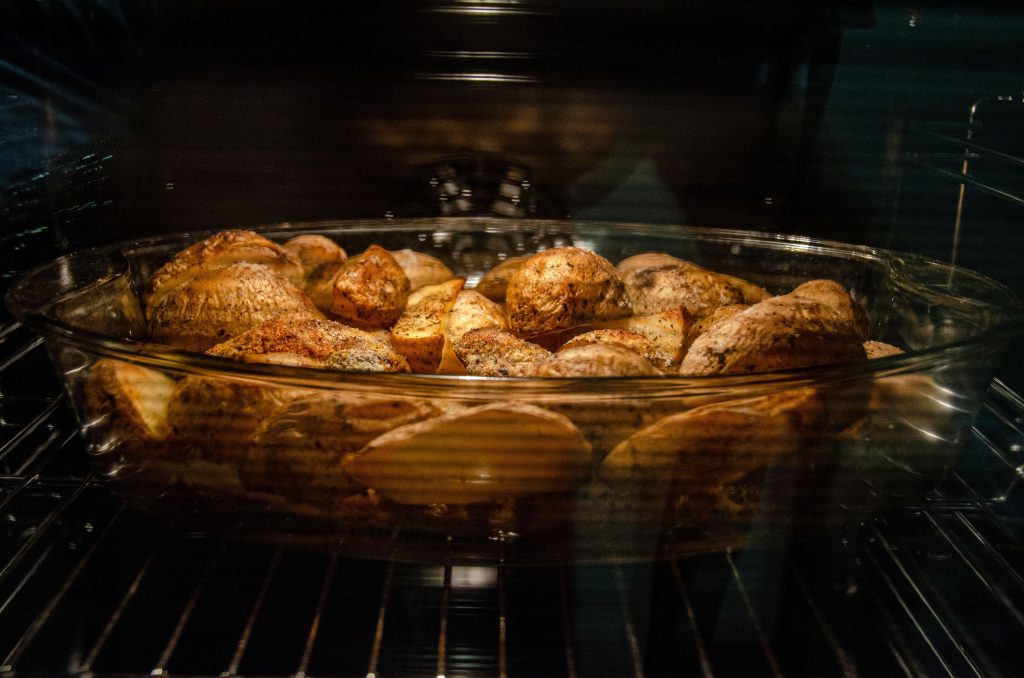 Blick durch die Backofenscheibe auf eine Auflaufform mit Kartoffeln