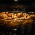 Blick durch die Backofenscheibe auf eine Auflaufform mit Kartoffeln